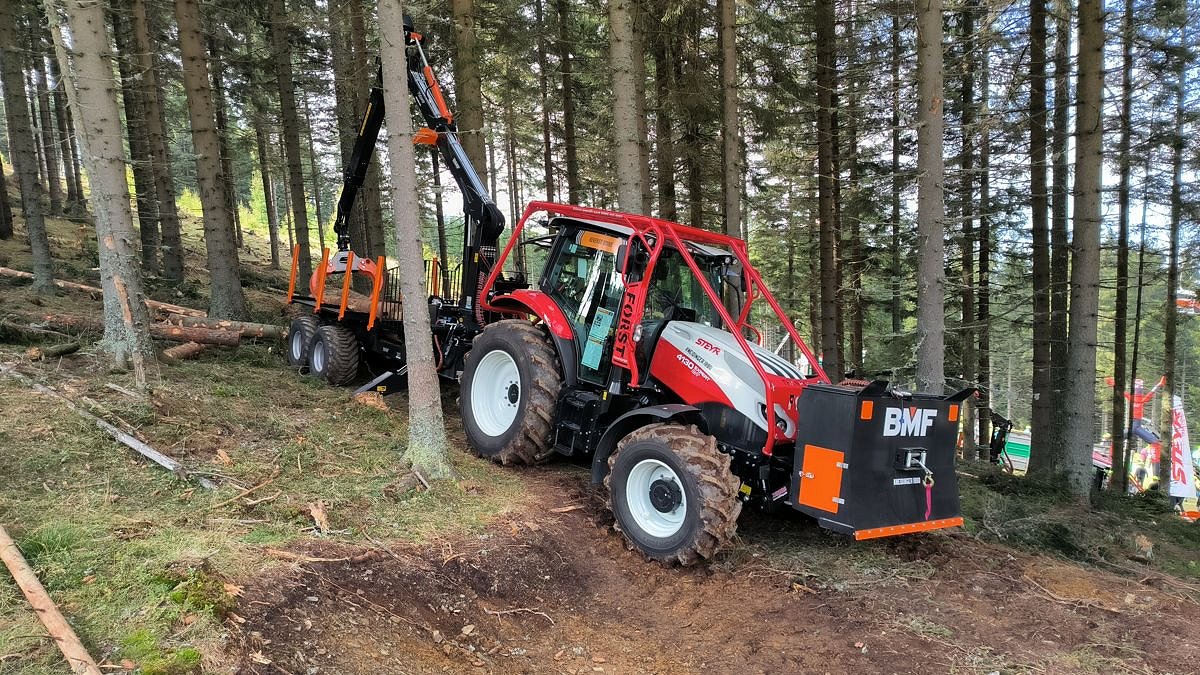 Slika 5: Traktor Steyr z zaščitnim lokom z zadaj pripeto gozdarska polprikolico, spredaj pa pripetim gozdarskim zabojem (foto: M. Jež)